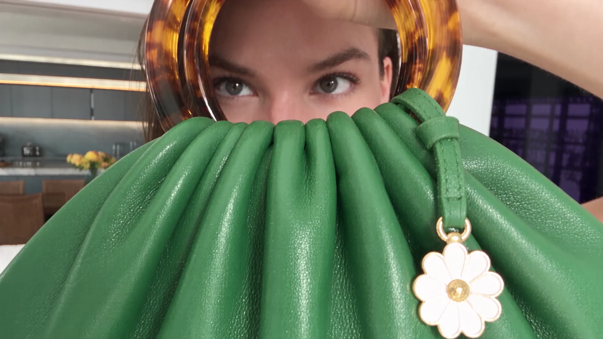 Primer plano de un bolso verde en una creatividad publicitaria, ejemplo de activo adaptable a variantes