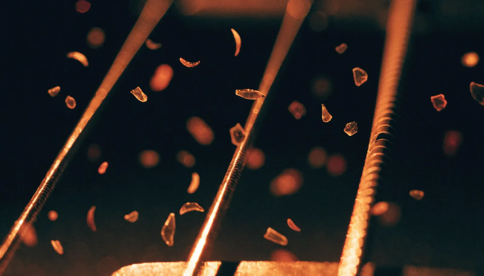 Cuerdas de guitarra en macro con ascuas encendidas, proyecto Mestisay Volcán