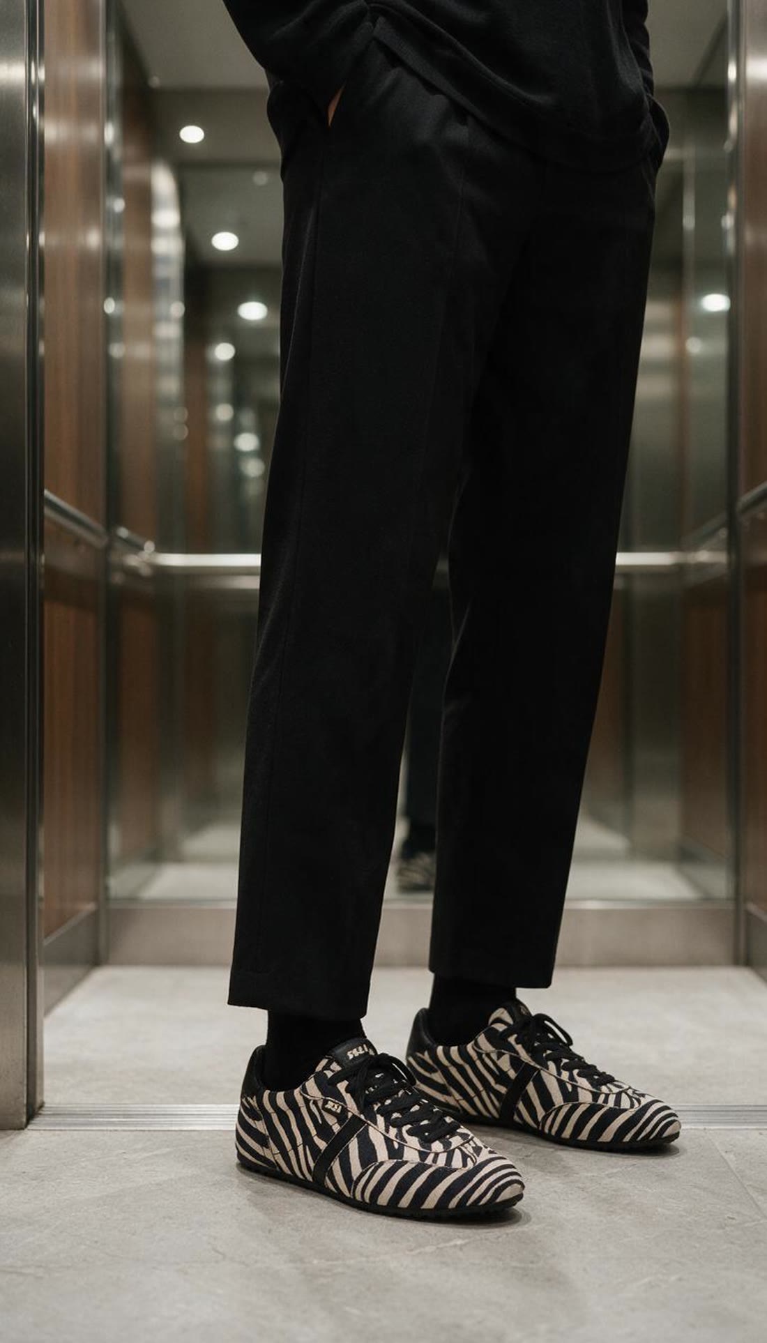 Look total negro en un ascensor de espejos con zapatillas XTI cebra