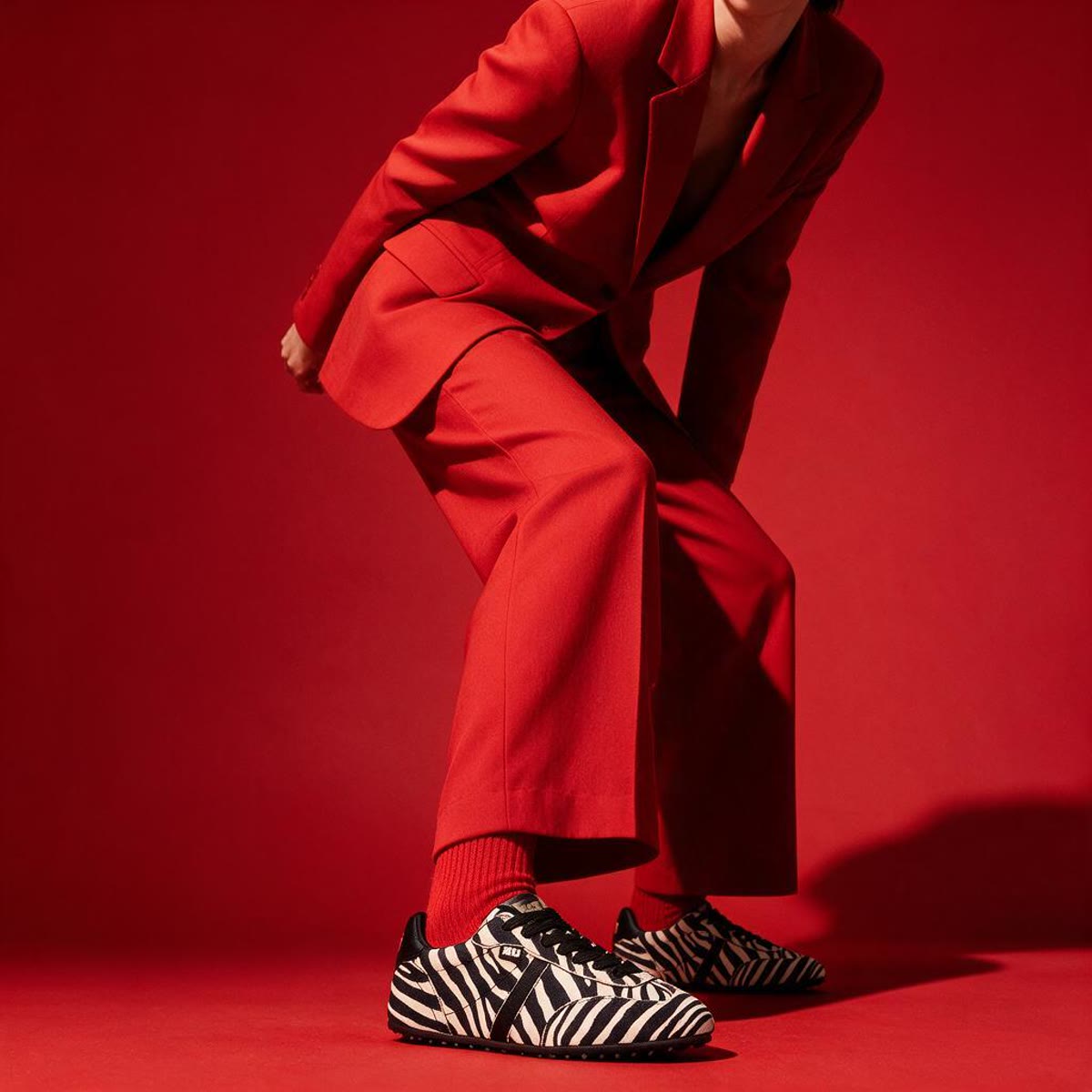 Editorial en rojo XTI con zapatillas cebra